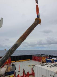 Clamp laying Wellhead onto vessel deck
